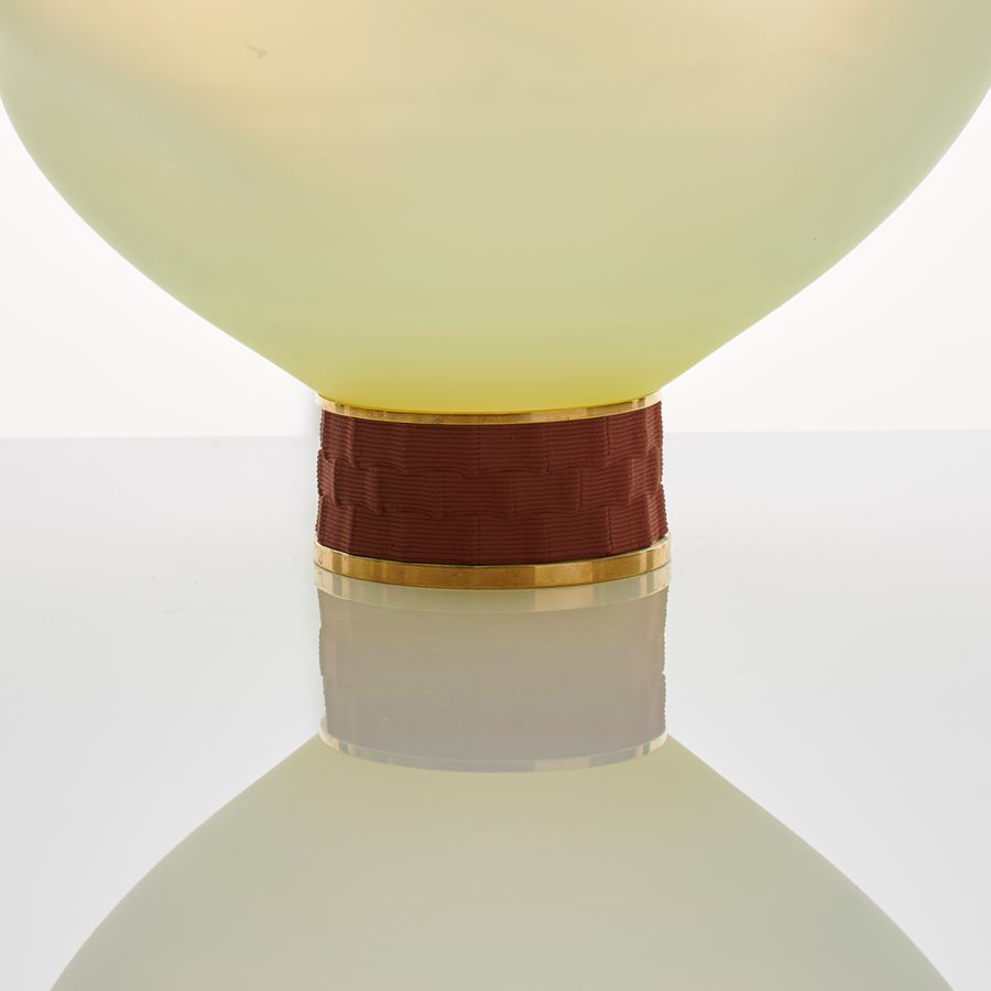 cream art glass sculpture of blob shaped blown glass with bronze base