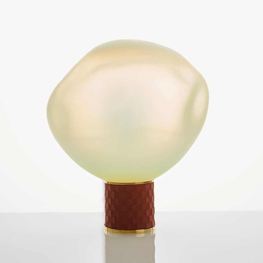 cream art glass sculpture of blob shaped blown glass with bronze base