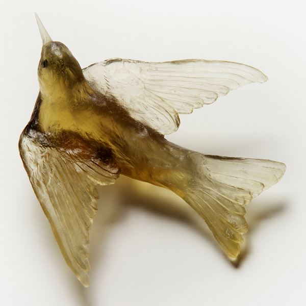 glass sculpture of swallow bird in yellow gold