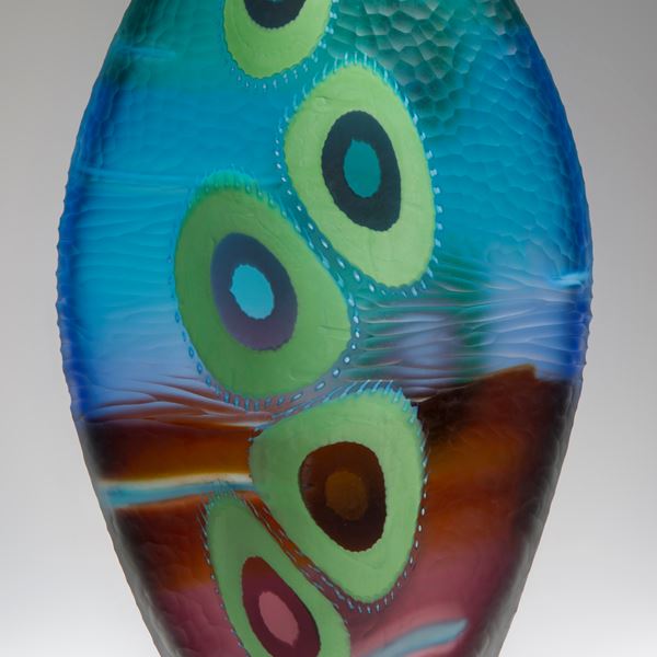 colourful glass vase sculpture with elliptical shapes in deep blue dark red and light green
