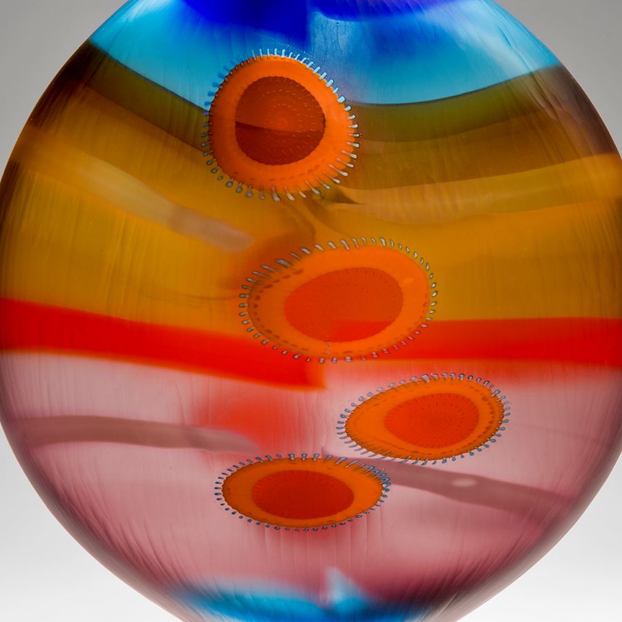 brightly coloured round glass vase with elliptical shapes