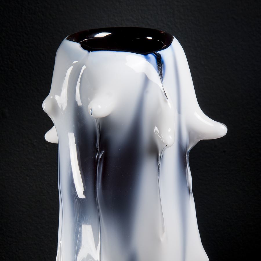 tall white abstract glass sculptre with random protruding scale-like edges 
