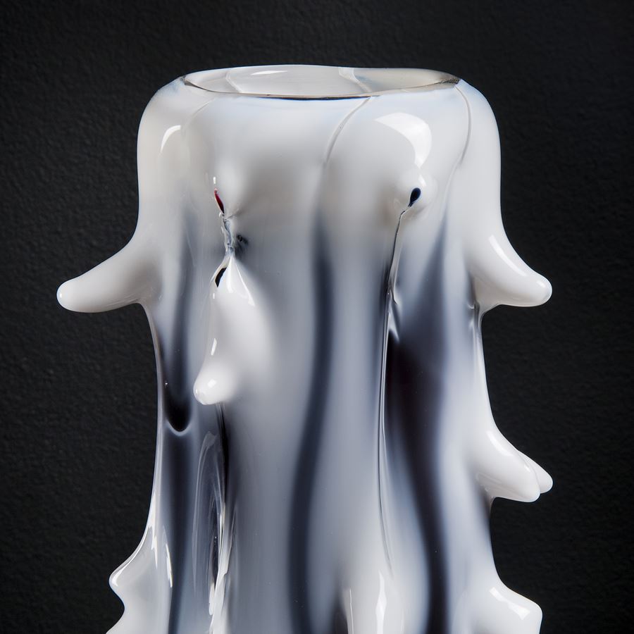 tall white abstract glass sculptre with random protruding scale-like edges and black shading