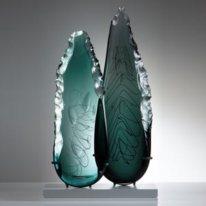 two leaf-shaped glass art sculptures in aqua and jade on clear rectangular base