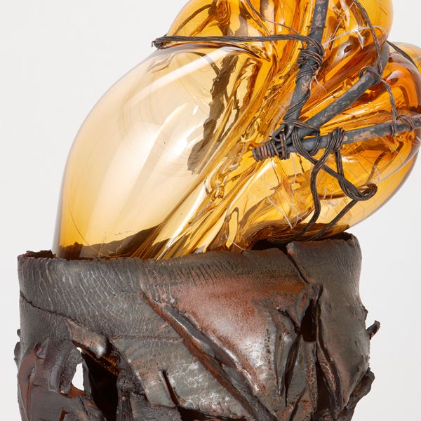 amber glass ornament in teracotta container with copper wire