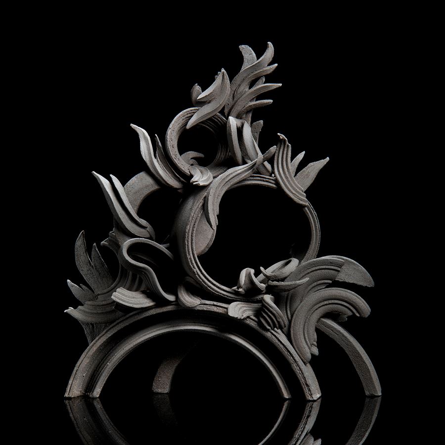black stoneware sculpture in classical style with arcs and flares