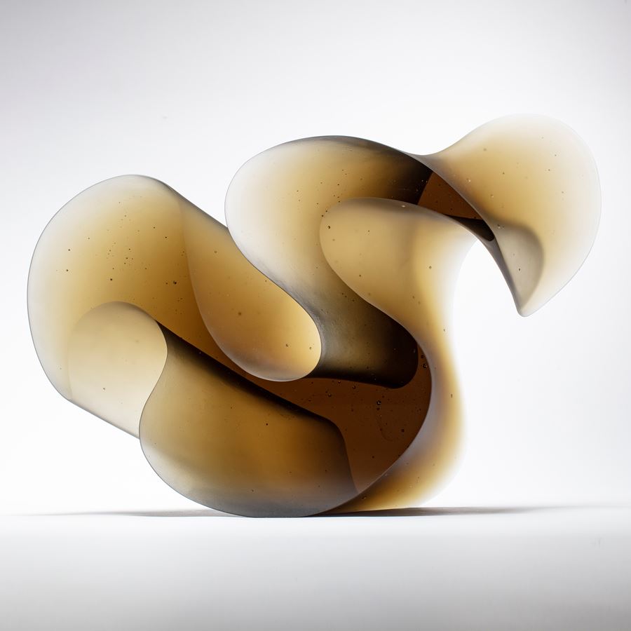 bronze brown fluid lined sculpture with dramatic sweeping curves made from cast glass