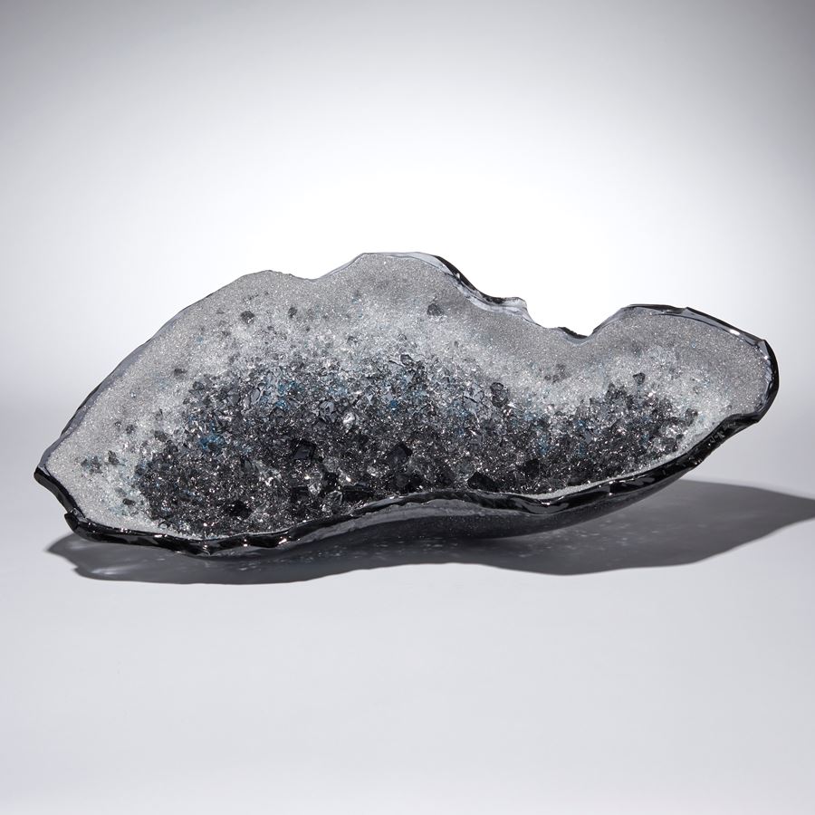 grey and blue oyster shell shaped glass sculpture with a twinkling crystal covered interior