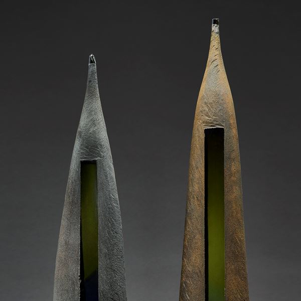 grey brown green and blue tall pointed aged looking twinned sculptures with weathered appearance handmade from blown glass and steel