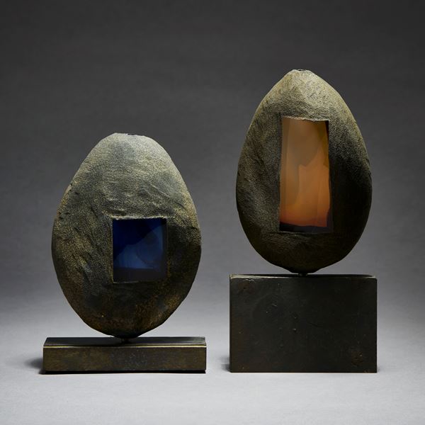 grey and brown hand made ovoid shaped glass and metal sculpture with square geometric aged metal base and rectangular orange glass window