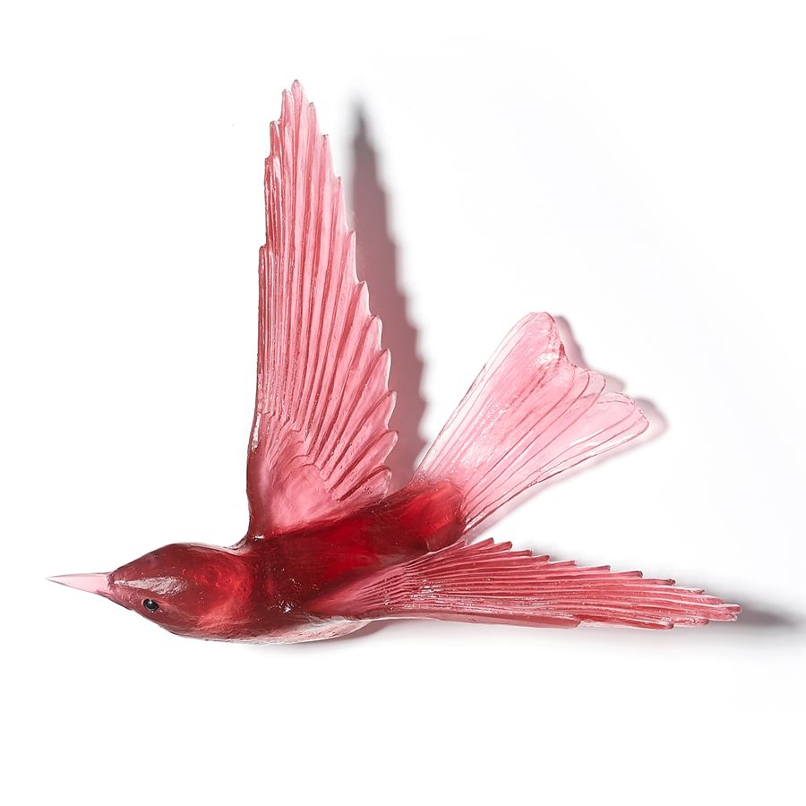 glass sculpture of a bell bird in deep pink