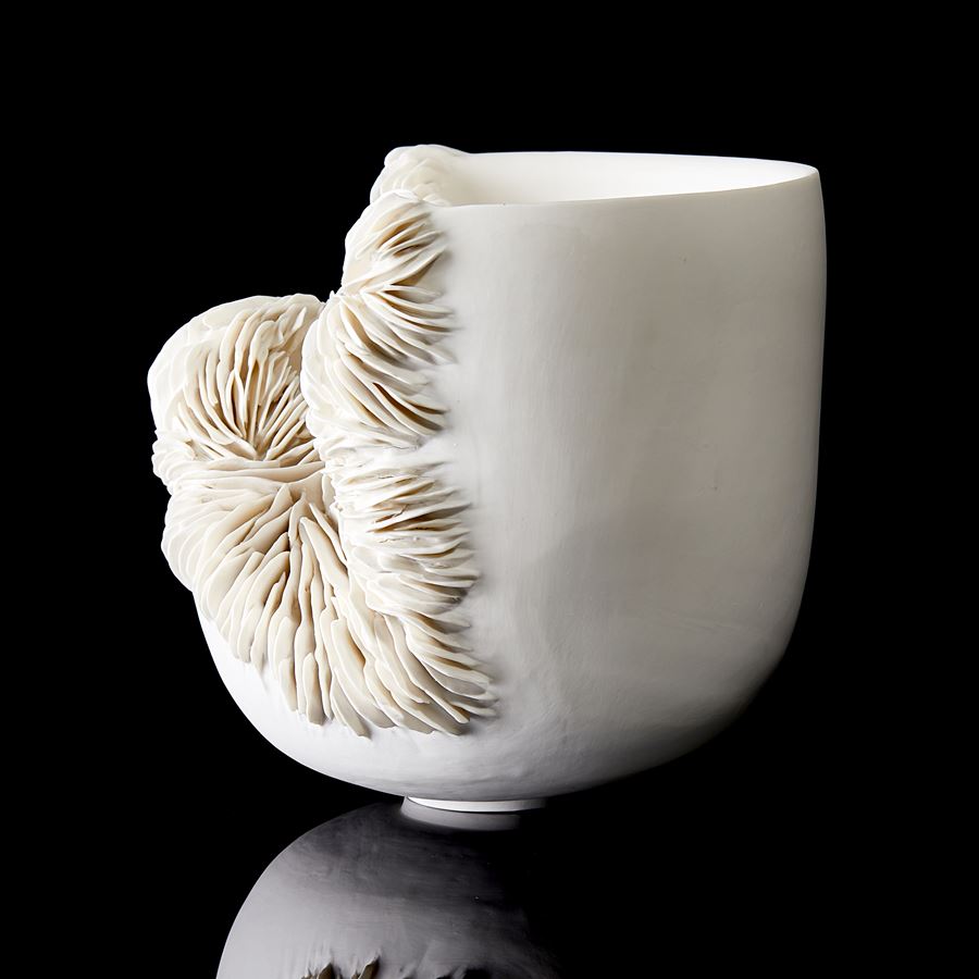 sculptural ceramic bowl with cut away side filled with ridged decoration handmade from porcelain