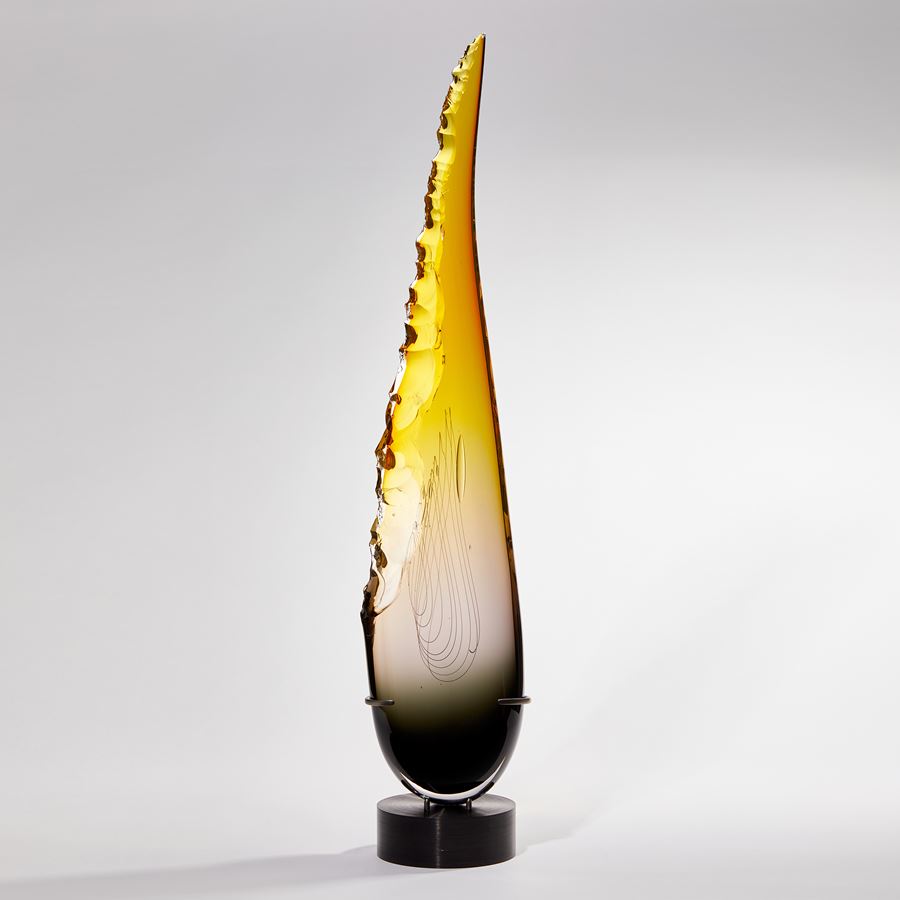 tall pointed teardrop shaped sculpture in grey and yellow with chipped edge handmade from glass
