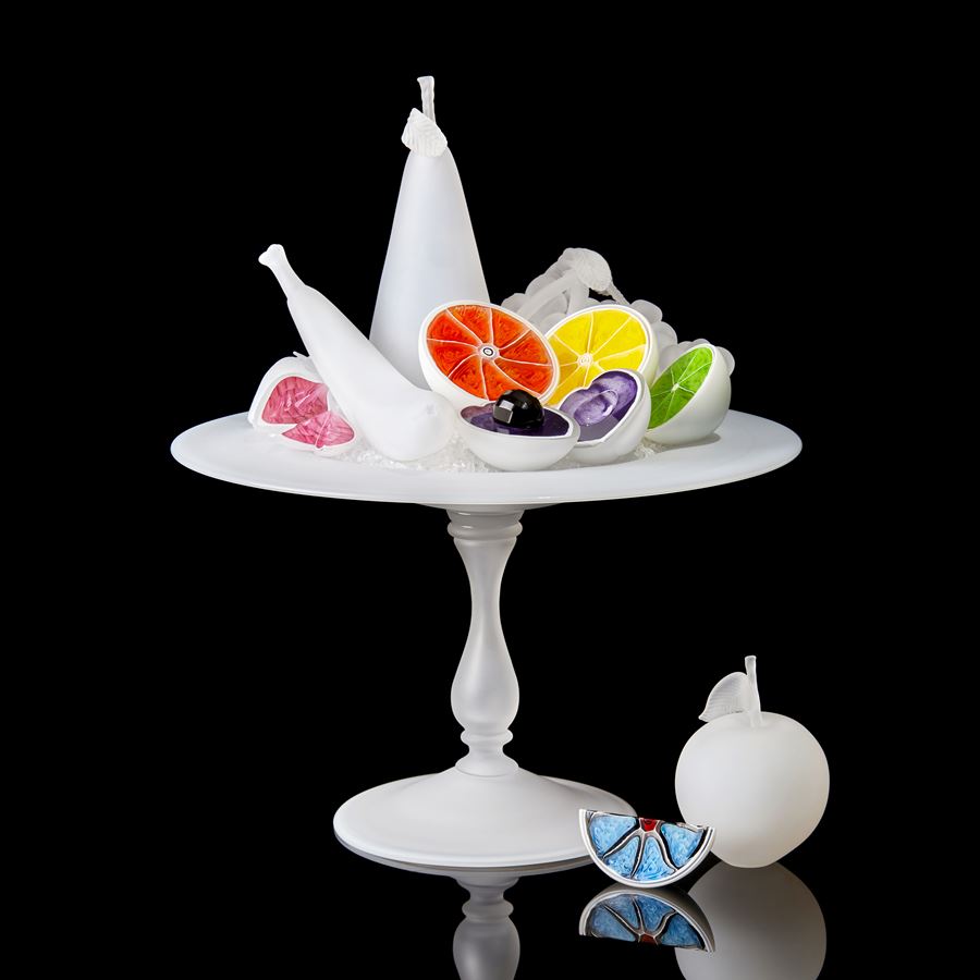 white centrepiece with bisected white fruits each with a different coloured interior handmade from glass