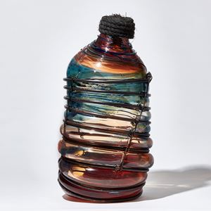 red blue and brown metal caged leaning bottle shaped glass sculpture with rope stopper detail