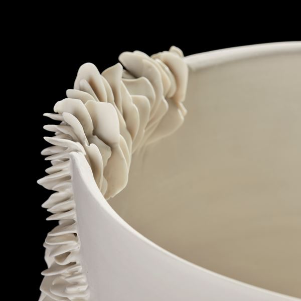 white deep wide bowl with the exterior partially covered in organic fins and ridges handmade from porcelain