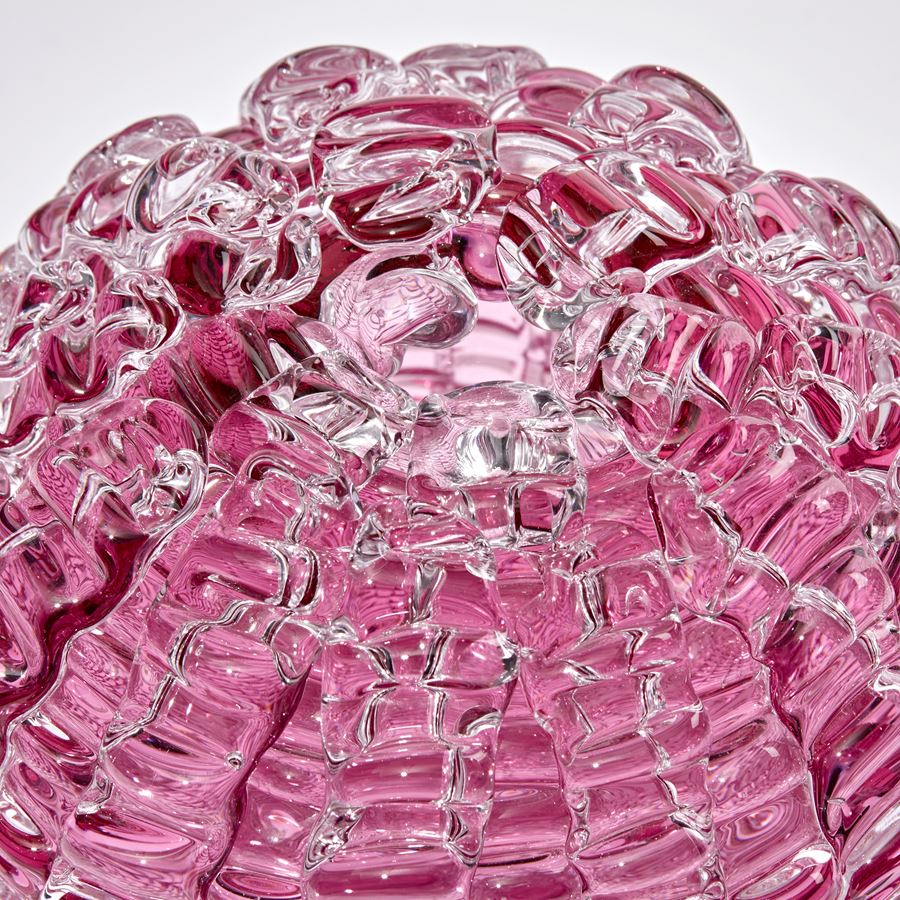 pink ridged globe shaped sculpture handmade and sculpted from glass with small top opening