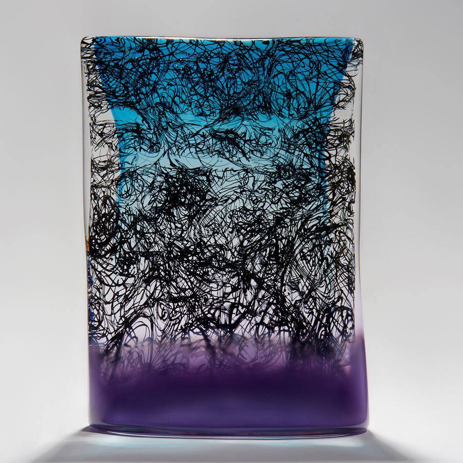 blue clear and purple tablet shaped handmade glass sculpture with black messy script