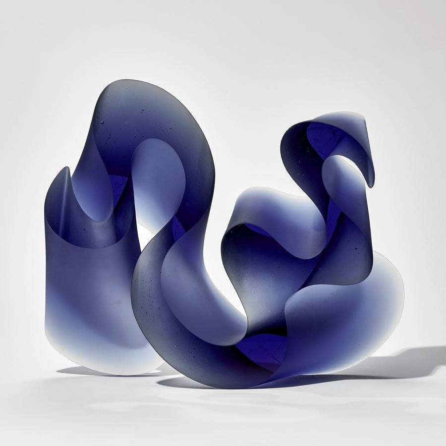 deep midnight blue thick curling abstract line sculpture with flat front and back handmade from cast glass