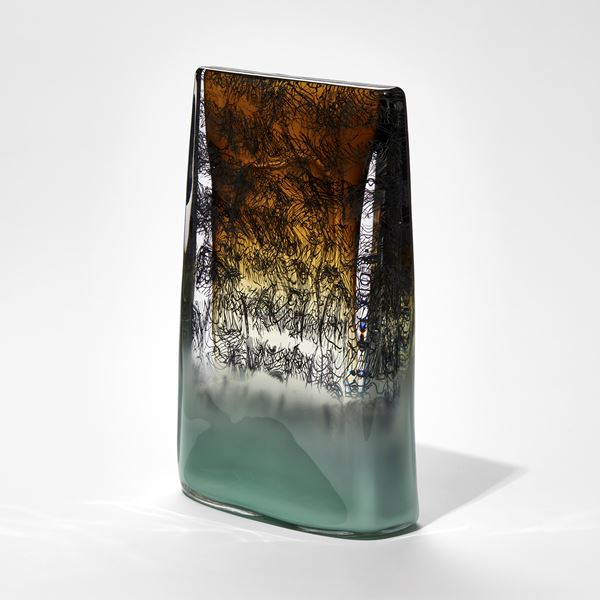 celadon green and amber sone tablet shaped sculpture with black wiggly lines text handmade from glass
