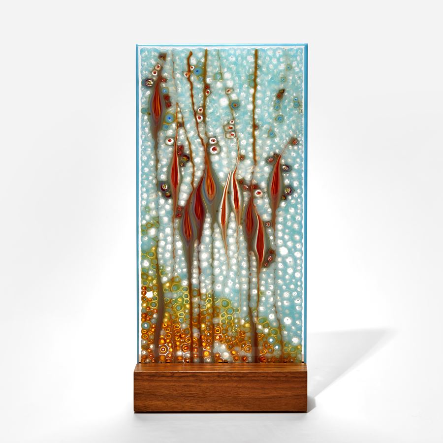 soft aqua blue and red panel handmade from glass with intense organic pattern and wooden base