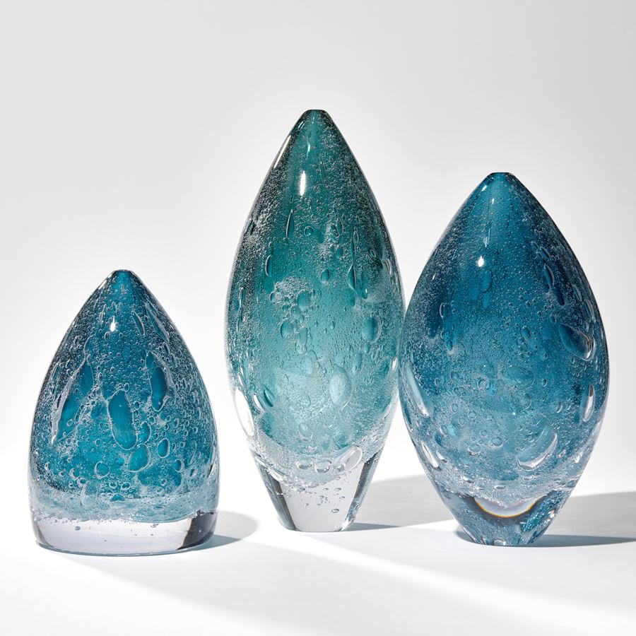 deep blue soft cone shaped sculpture with effervescent trapped bubbles handmade from glass