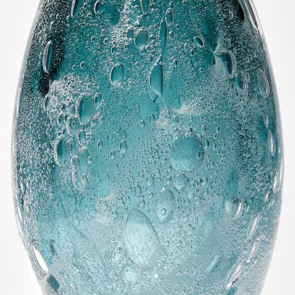 dark aqua and sea green tall pointed sculpture with trapped bubbles hand made from glass