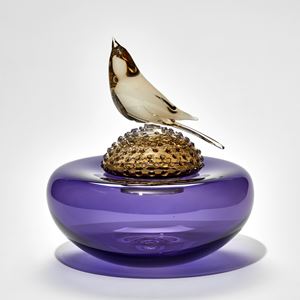 purple round cushion with spotted bronze dome above with bird perched on the top hand made from glass