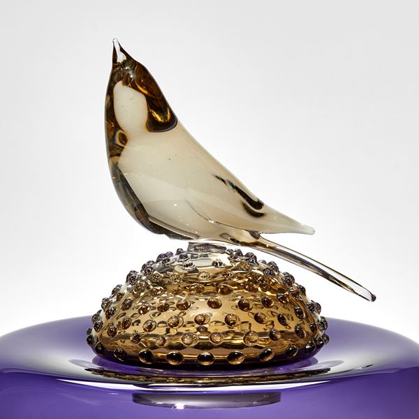 purple round cushion with spotted bronze dome above with bird perched on the top hand made from glass