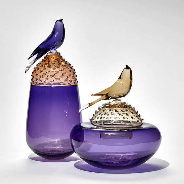 purple and bronze round lidded domed jar with bird perched on the top hand made from glass