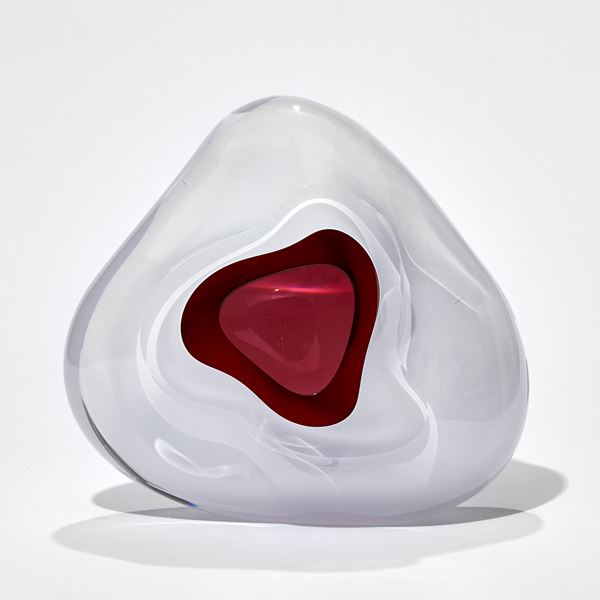 white soft rounded triangular sculpture with rich pick interior and front opening