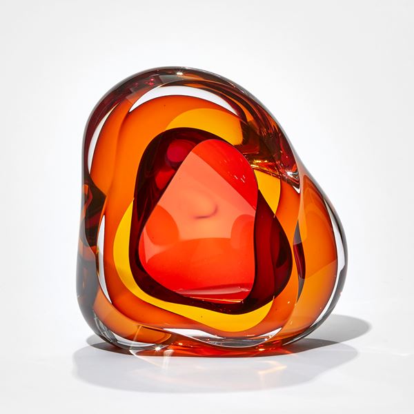 red and orange amorphous soft  looking sculpture hand made from glass with central cavity