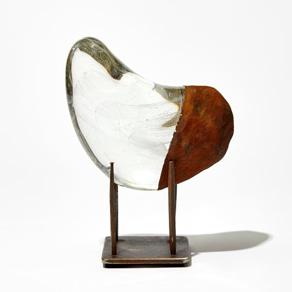 clear and opaque rust curved sculpture with fine wispy inner detail handmade from glass on a three pronged steel base
