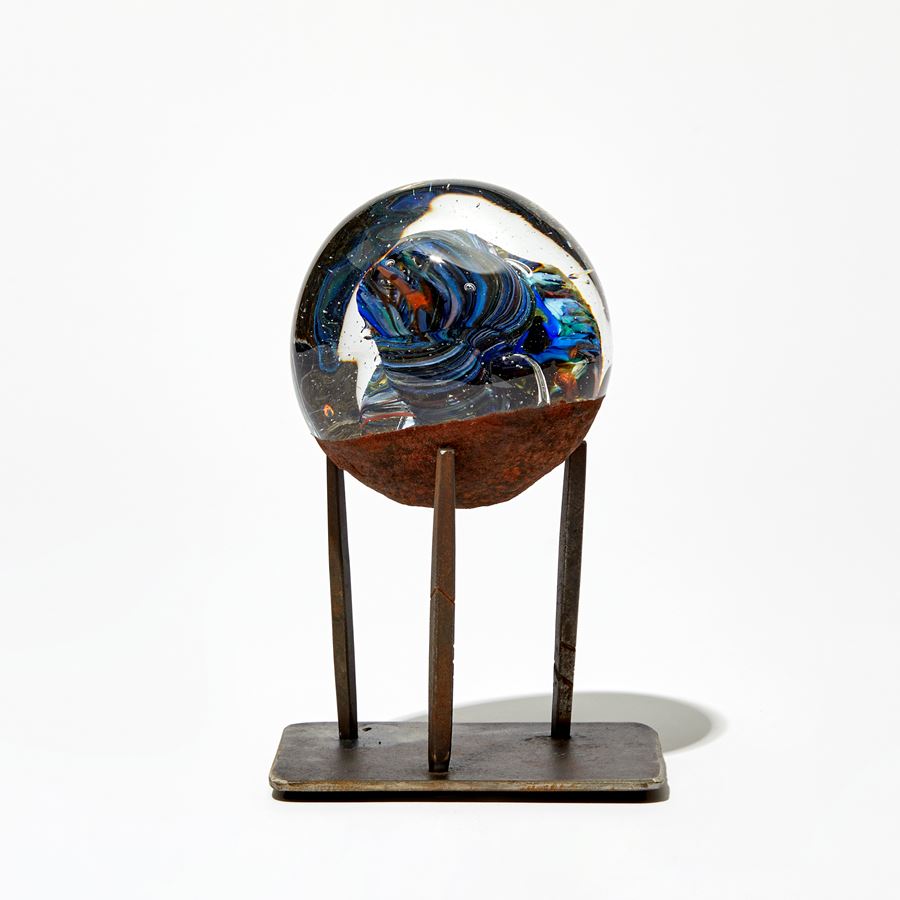 blue clear and brown meteorite round glass sculpture on steel pronged base