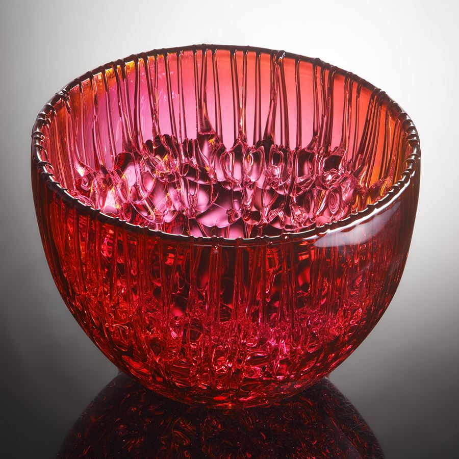 bright pink and amber round curved bowl with dribbled pooled internal texture handmade from glass