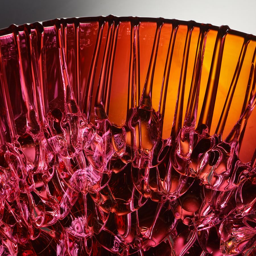 bright pink and amber round curved bowl with dribbled pooled internal texture handmade from glass