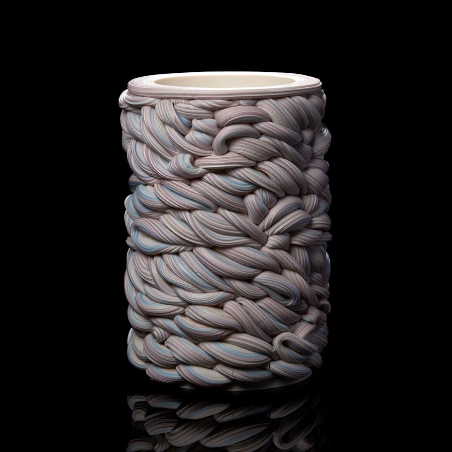 handmade cylindrical shaped vessel created from woven striped tubes of clay in white purple and blue