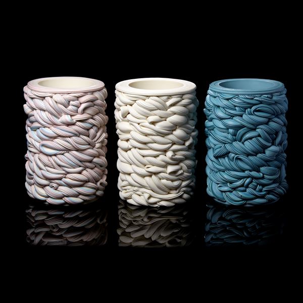 handmade cylindrical shaped vessel created from woven striped tubes of clay in white purple and blue