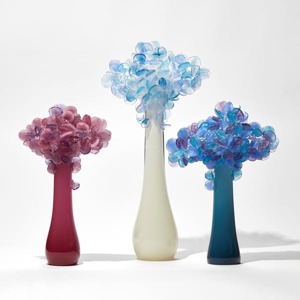 deep teal sculptural tree with simplified lollipop shaped leaves in blues purples and pinks handmade from glass