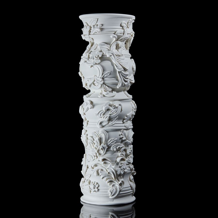 statuesque porcelain column covered in organic flourishes and relief leaf like swirling detail