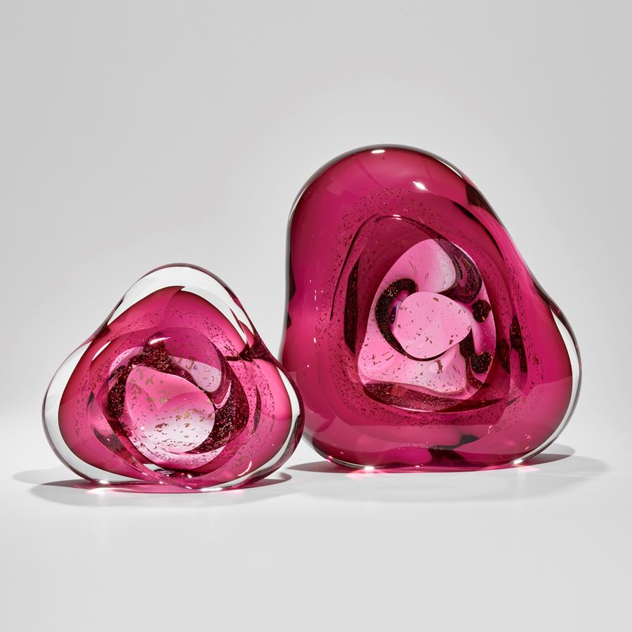 blobby pink mass of glass with central hole and swirling mass of trapped small fragments of glass