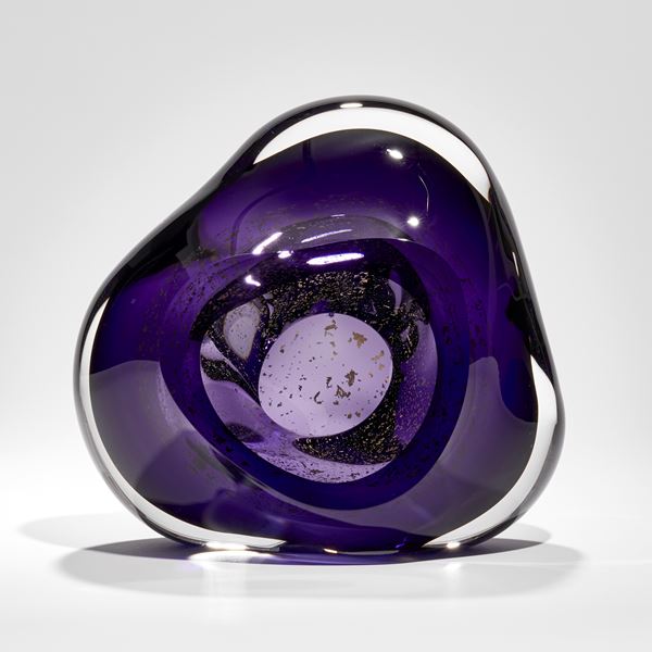 soft formed rich purple and clear glass sculpture with inner trapped gold fragments circling an inner cavity