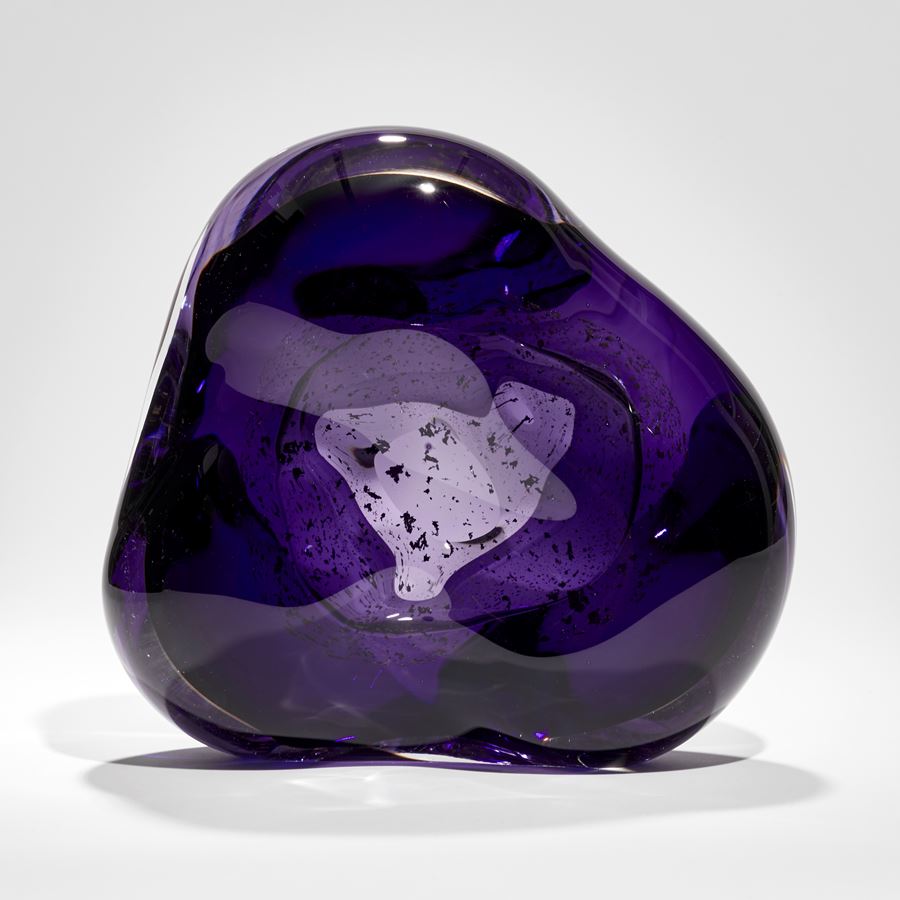 soft formed rich purple and clear glass sculpture with inner trapped gold fragments circling an inner cavity
