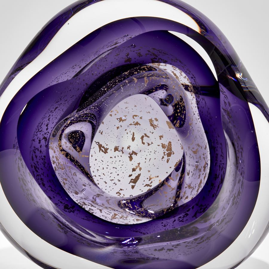 soft rounded clear and rich purple hand blown glass sculpture with floating gold leaf elements