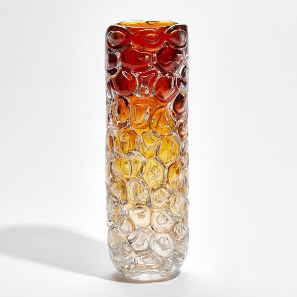 cylindrical vase fading upwards from clear yellow to amber appearing as if made from stacked oversized bubbles handmade from glass