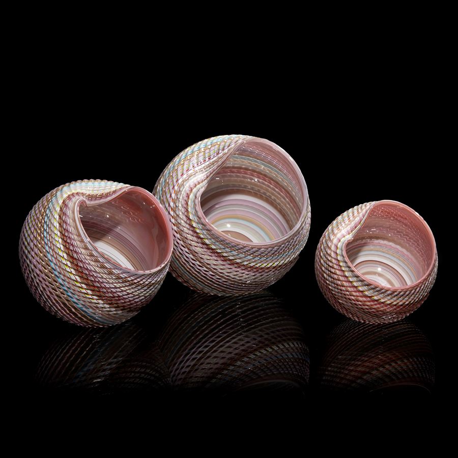 round shell sculpture in pastel colours with ridged surface and shiny interior made from glass
