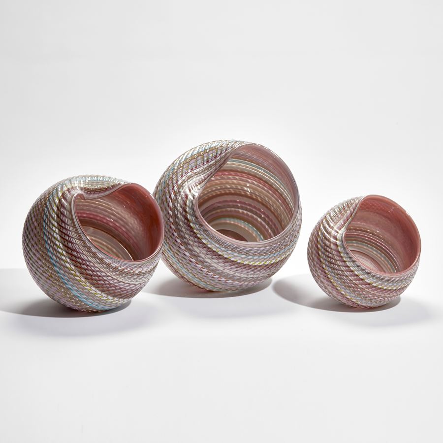 round shell sculpture in pastel colours with ridged surface and shiny interior made from glass