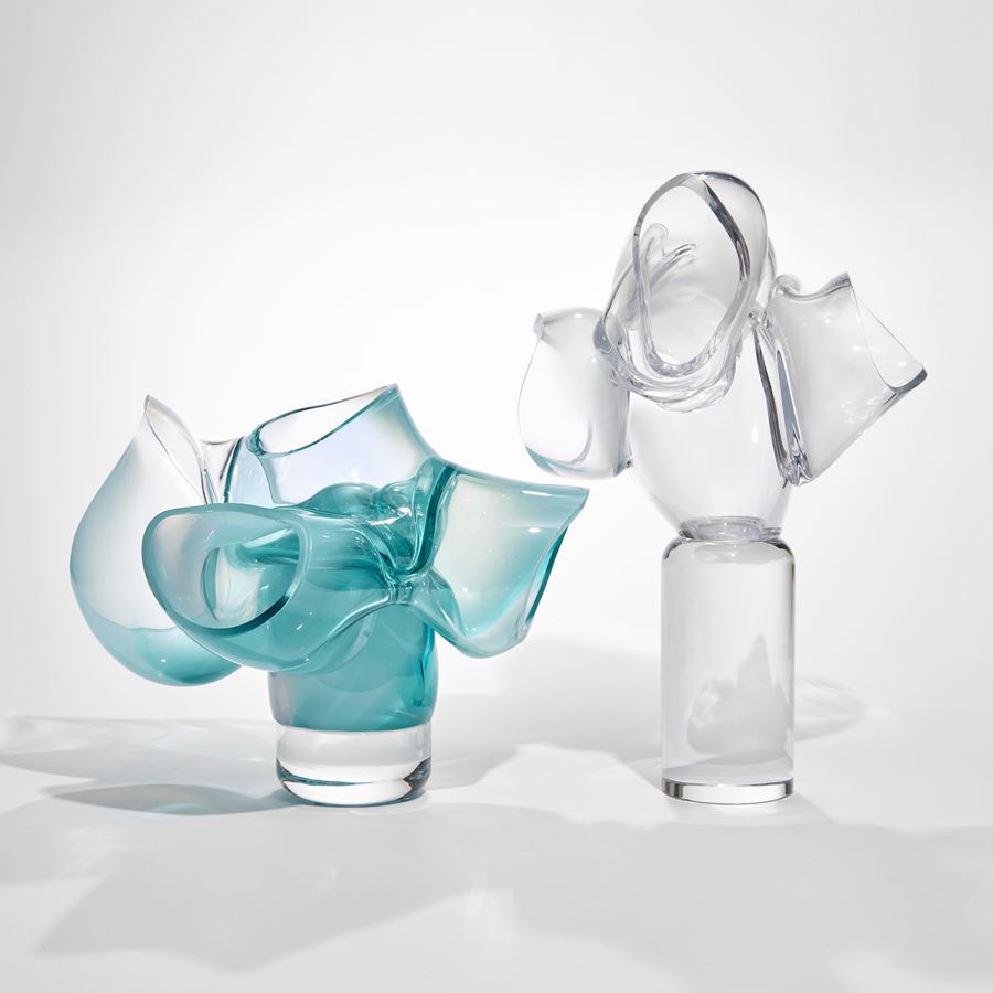 abstract sculpture of soft tubular bubbles in transparent clear and turquoise glass held aloft on a central solid trunk hand made from glass