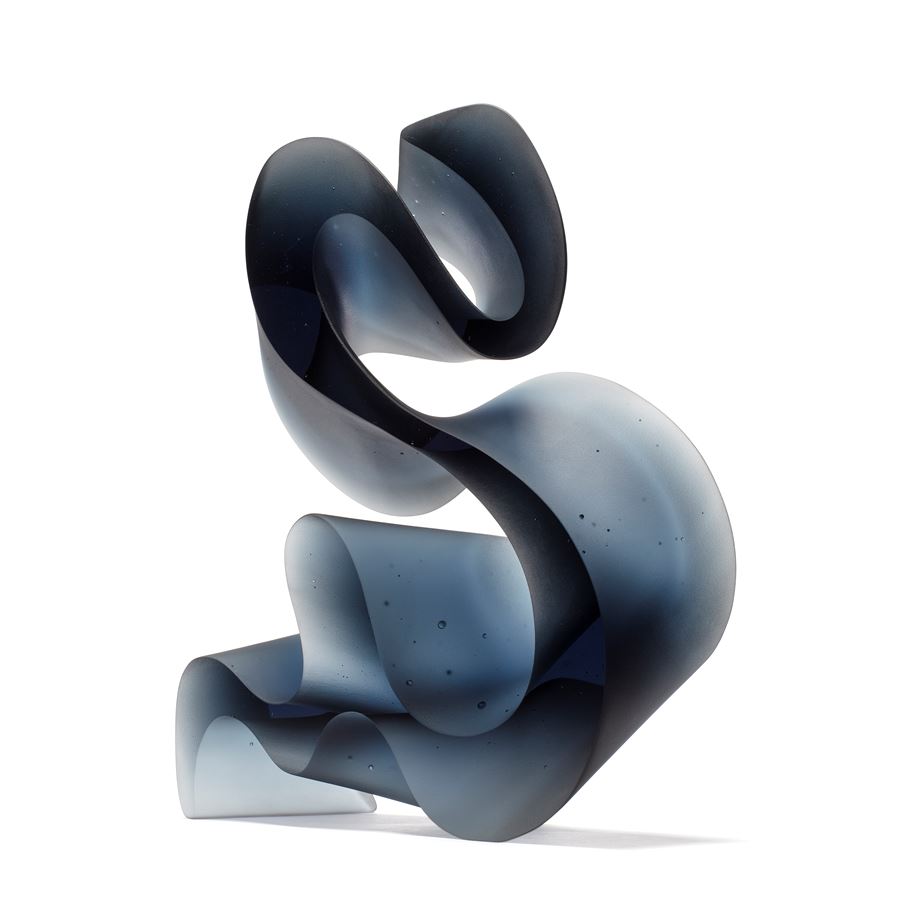 dark grey blue curved abstract ribbon lined sculpture hand made from cast glass standing on end