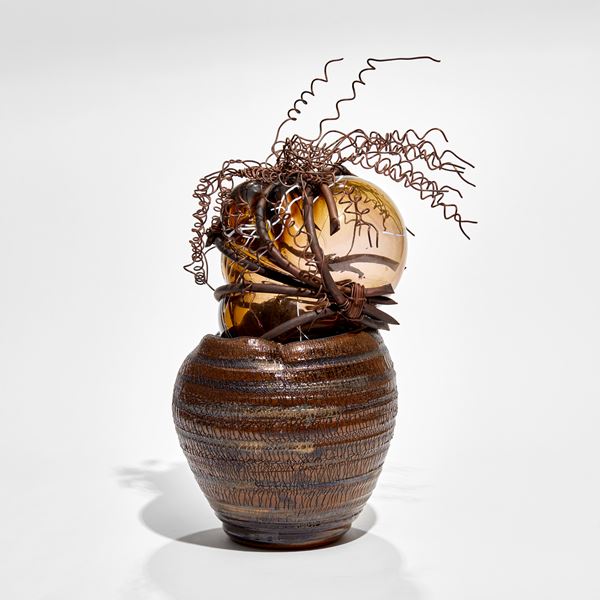 brown ridged ceramic urn containing a bursting forth bubble of amber glass bound in copper with copper wire cork screw hair